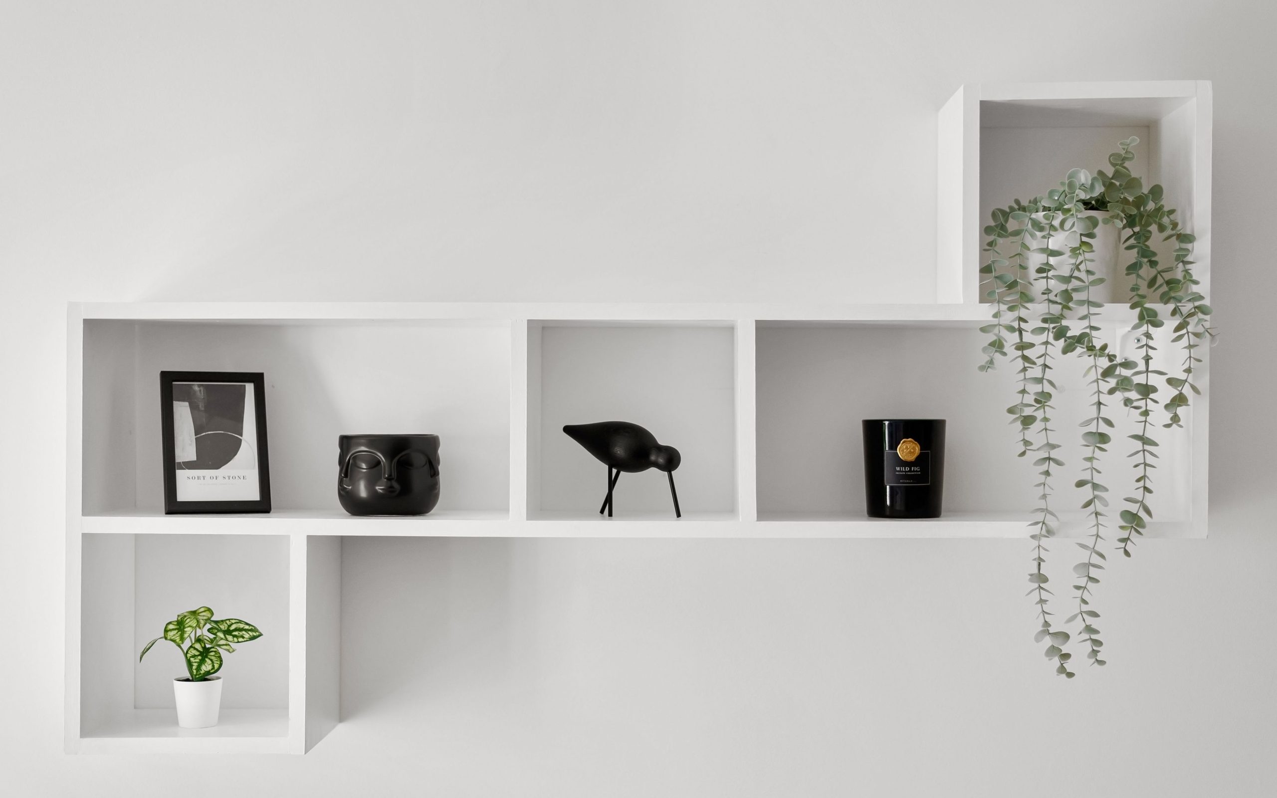 Étagères murales blanches et rangements d’appoint dans un salon lumineux